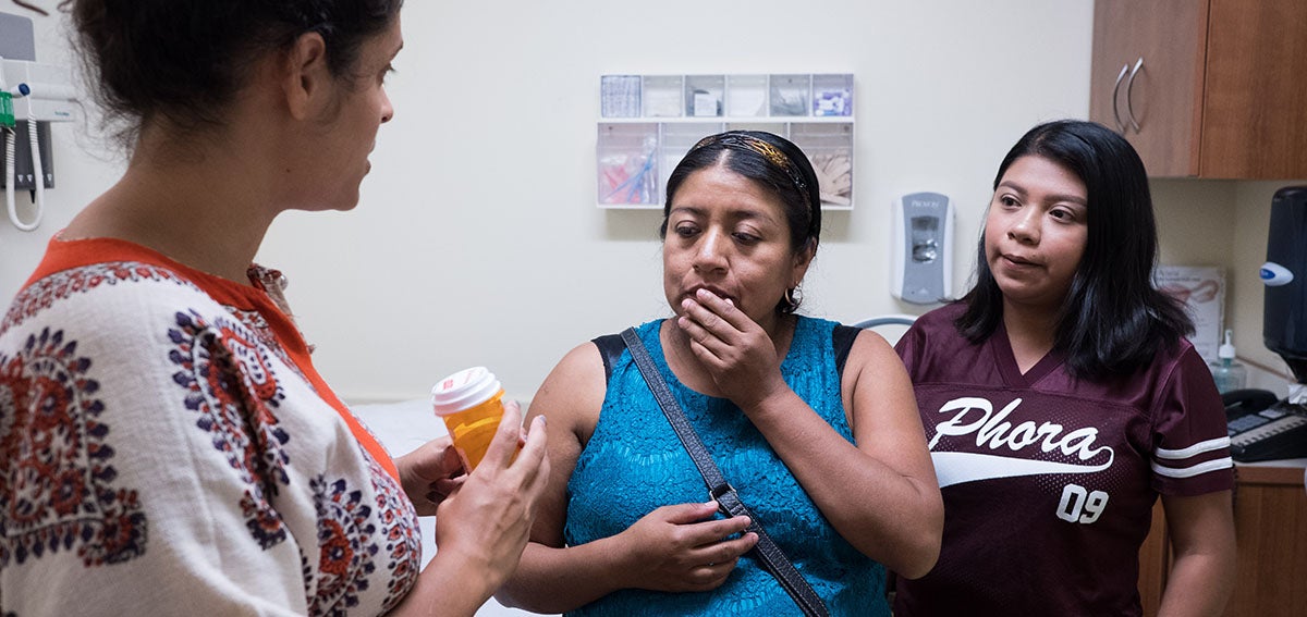 Practitioner consults with patient about medication while patient's daughter listens