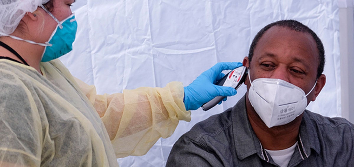 Man having his temperature taken at a COVID-19 Testing Site