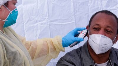 Man having his temperature taken at a COVID-19 testing site.