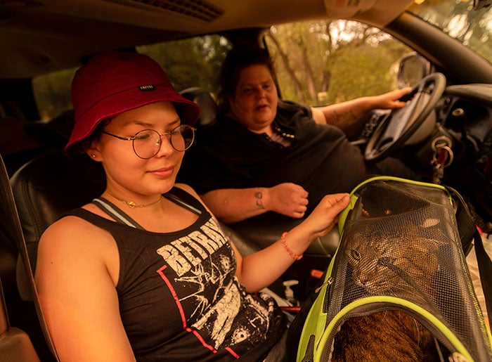 Carrie Paulson and her daughter McKenna Bernard hold a cat named Stripper in their SUV inside the evacuation zone outside Vacaville.