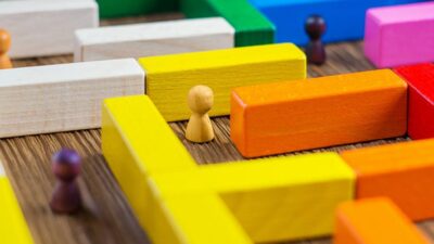 wood game pieces in a maze made of toy blocks
