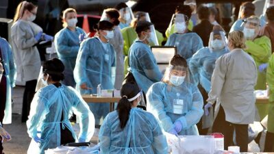 Medical personnel prepare to test hundreds of people lined up in vehicles Saturday, June 27, 2020, in Phoenix's western neighborhood of Maryvale for free COVID-19 tests organized by Equality Health Foundation