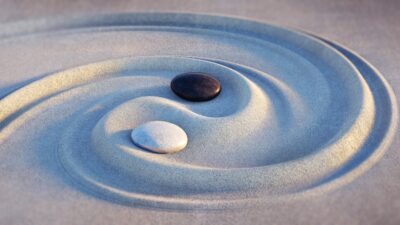 a swirl of sand with two rocks placed at the equilibrium point in the middle