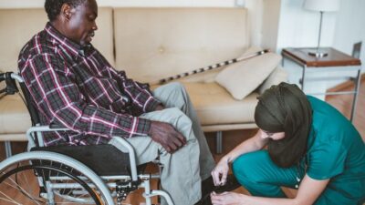 home health worker assist man in putting on his shoes