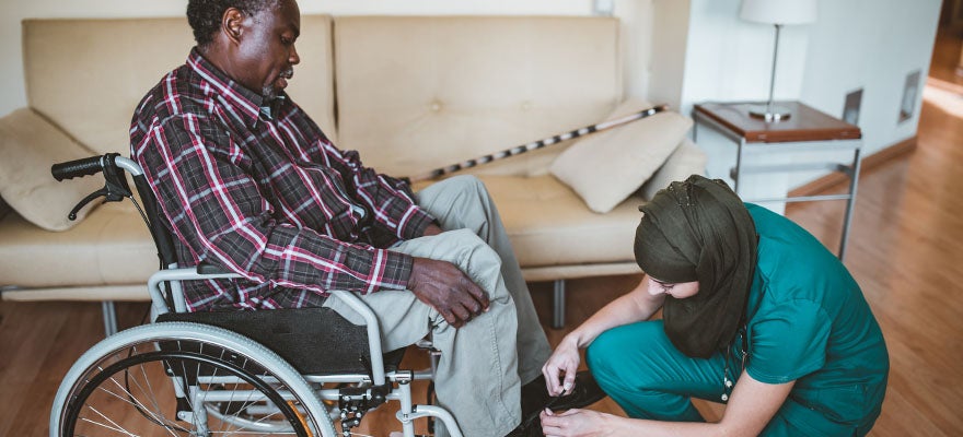 home health worker assist man in putting on his shoes