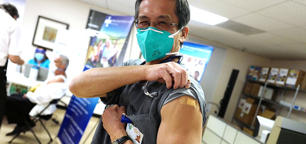 Doctor shows COVID-19 Vaccination on his arm.