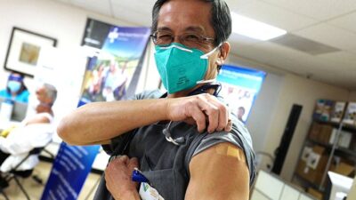 Doctor shows COVID-19 Vaccination on his arm.