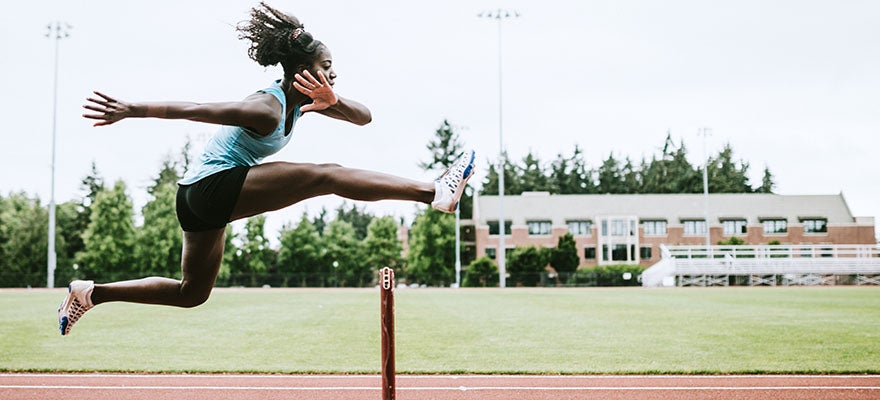 Runner leaping over a hurdle