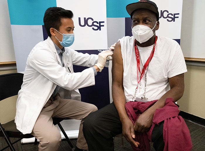 William Wyatt (right), an environmental services worker at UCSF, receives COVID-19 Vaccination