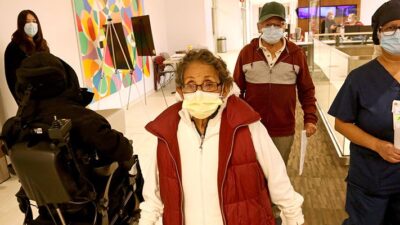 Maria Saravia, right, an Environmental Services Worker at Keck Hospital of USC, walks with her parents Sara, 81, and Juan Saravia, 83, where Marias parents will receive the vaccine against COVID-19