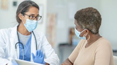 Doctor consults with patient in office visit.