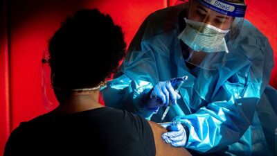 Nurse delivers COVID-19 vaccine to patient at mass vaccination site