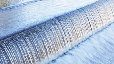 water flowing evenly over a spillway