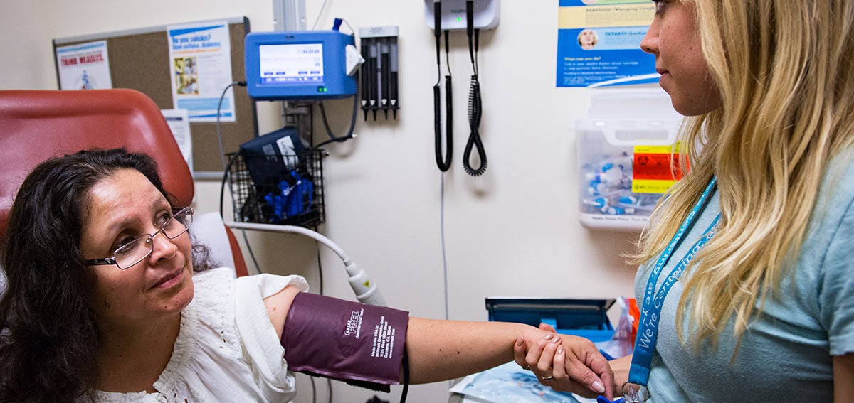 Woman receives a blood pressure check at clinic