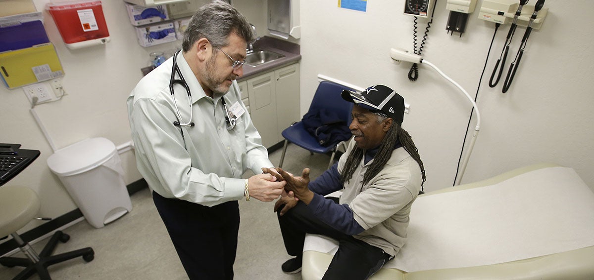 Doctor Leonid Basovich, left, examines patient Michael Epps who has medical insurance coverage through Medi-Cal