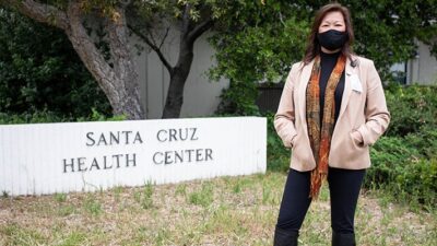 Santa Cruz County health services director Mimi Hall stands in front of the sign for the Santa Cruz County Health Center