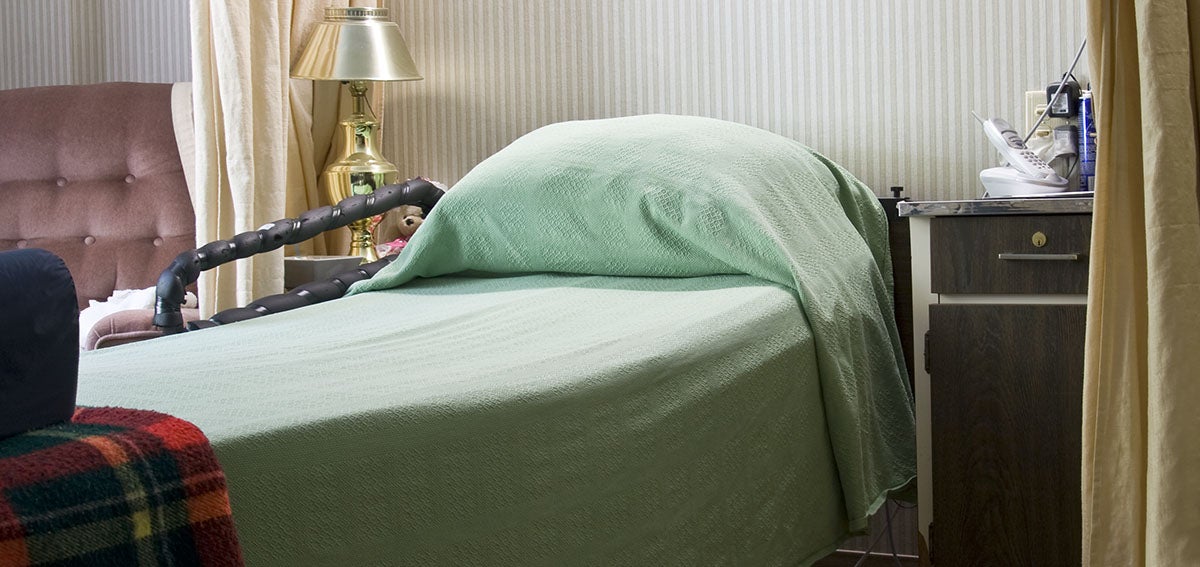 A bed is shown in a room at a nursing home