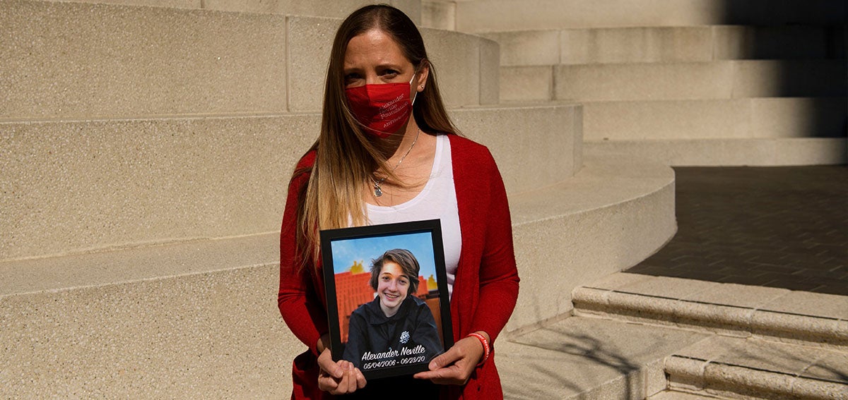 Amy Neville stands for a portrait with a picture of her son Alexander Neville, who died in June 2020 at the age of 14 of fentanyl poisoning.