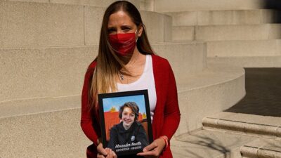 Amy Neville stands for a portrait with a picture of her son Alexander Neville, who died in June 2020 at the age of 14 of fentanyl poisoning,