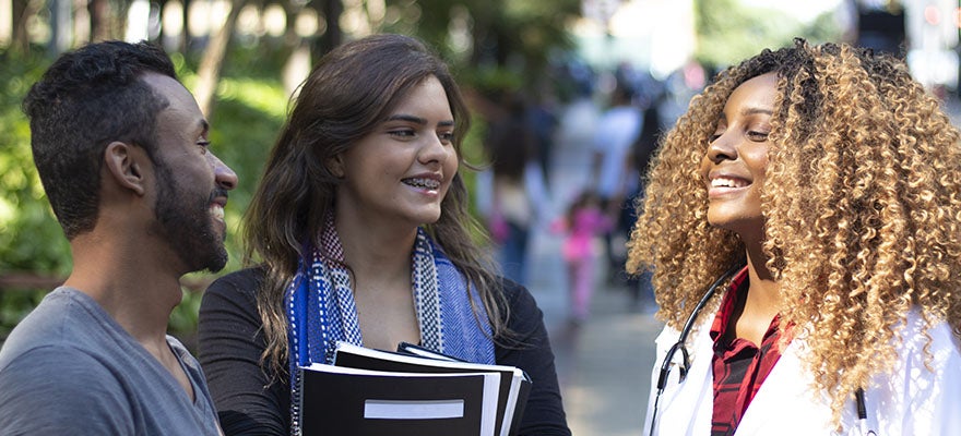 Medical students stop and chat on campus