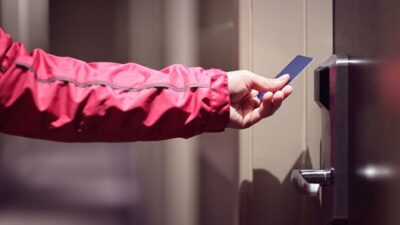 person preparing to insert key card into hotel room lock