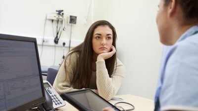 medical professional talks to patient and uses electronic health record
