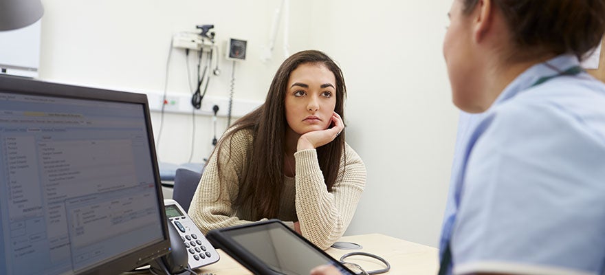 medical professional talks to patient and uses electronic health record