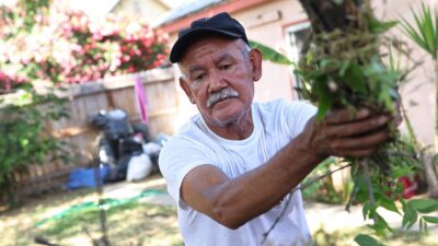 suncion Ponce, a farm worker originally from Puebla, Mexico, cleans up his yard on May 17, 2021 in Fresno, California.