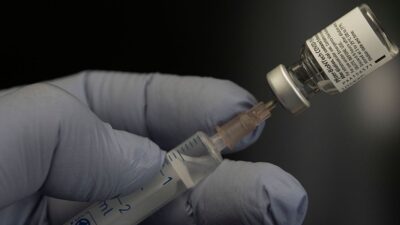 Filling a syringe with COVID-19 vaccine.