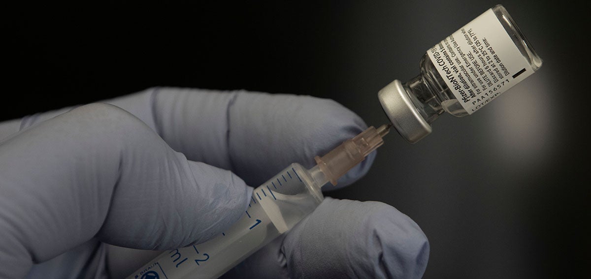 Filling a syringe with COVID-19 vaccine.