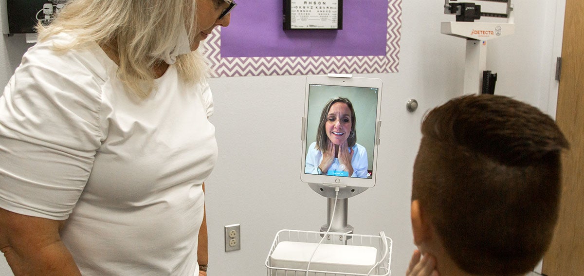 Nurse and patient talking to doctor via telehealth visit