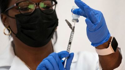 Doctor prepares COVID-19 vaccine shot.