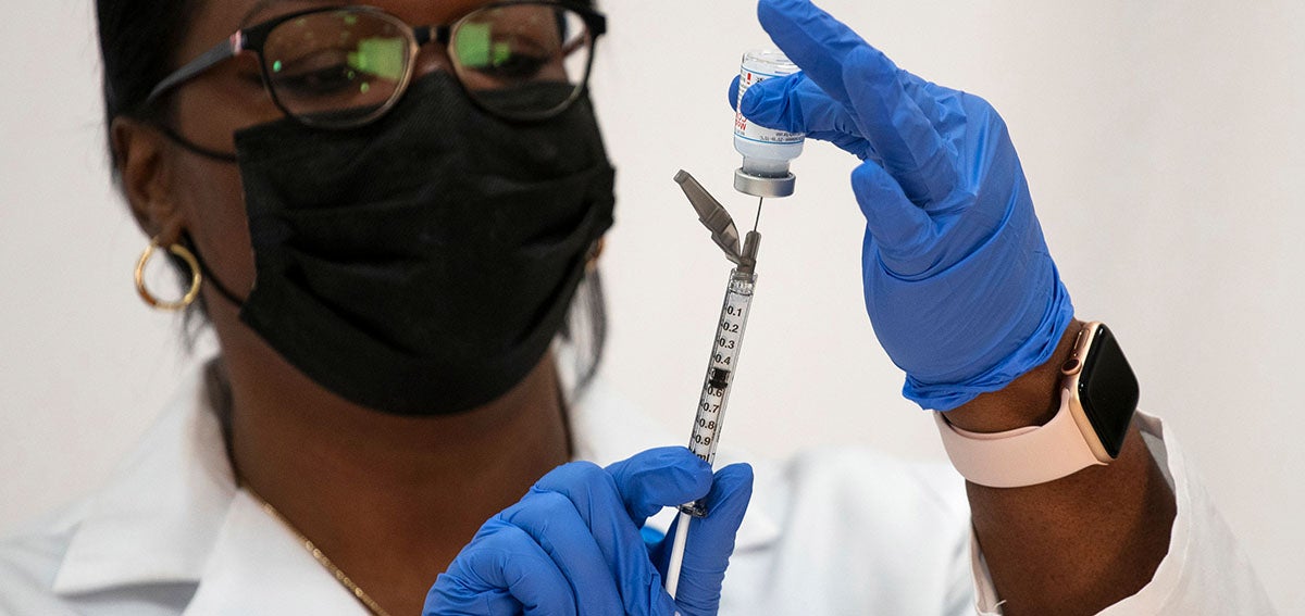 Doctor prepares COVID-19 vaccine shot.