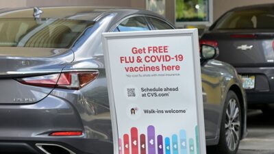 Sign for COVID-19 and Flu vaccinations at a drive-thru pharmacy