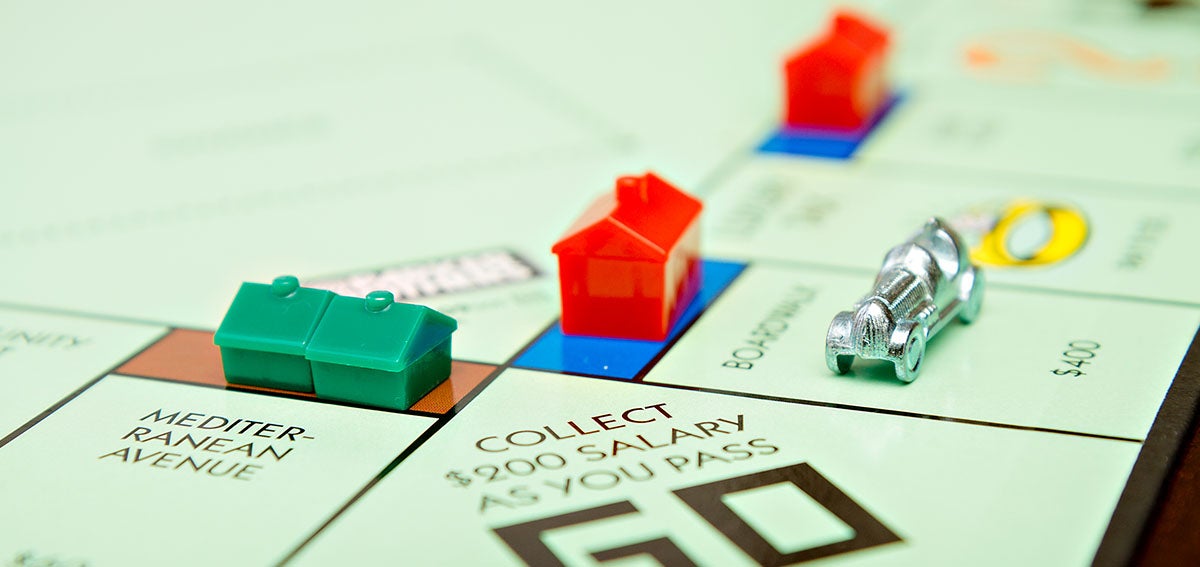 Plastic houses and hotels on Monopoly board