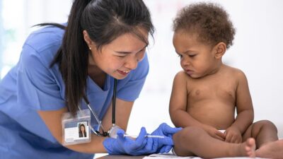 Baby with medical practitioner, getting a vaccination,