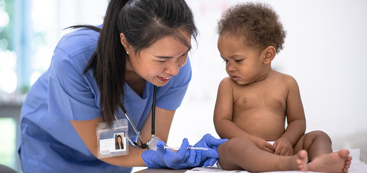 Baby with medical practitioner, getting a vaccination,