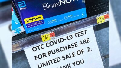 COVID-19 home test kits are seen on a shelf at a Walmart Neighborhood Market in Orlando, Florida.