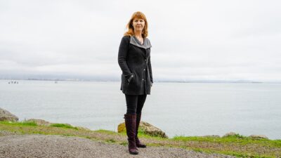Joanne Spetz of UCSF health policy institute standing outside, at the waterfront.