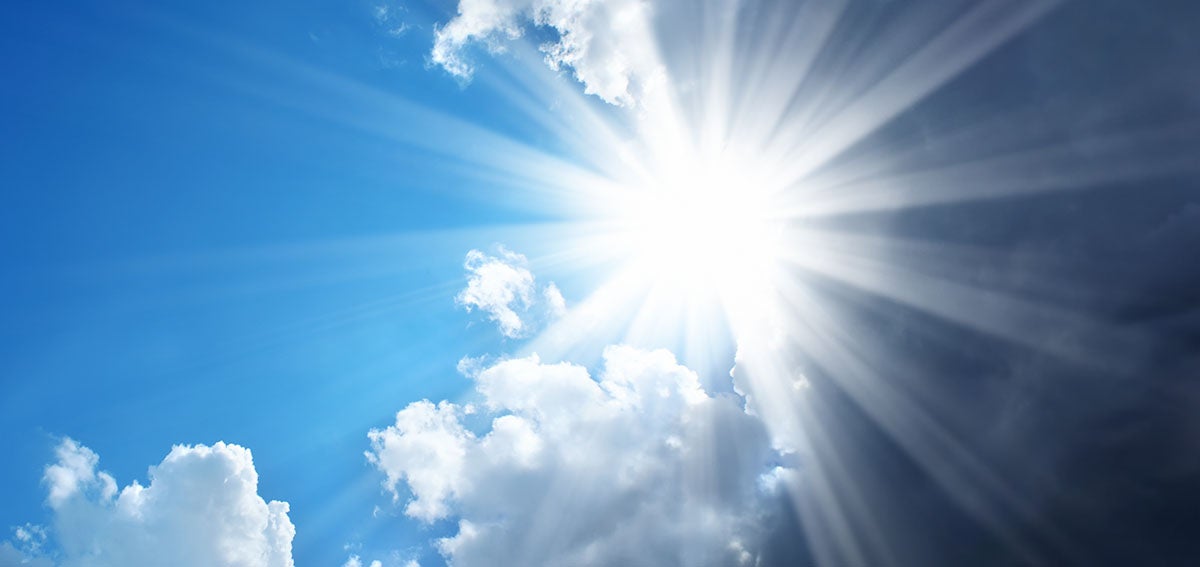 sun peeking out from behind gray clouds