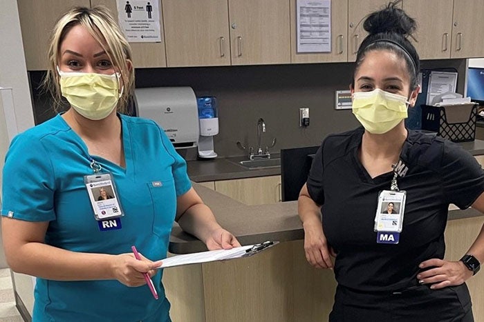 Alicia Gaeta, RN, and medical assistant Erika Guerrero stand side by side in medical office.