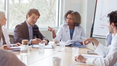 Group of medical practitioners having a serious discussion at a conference table.