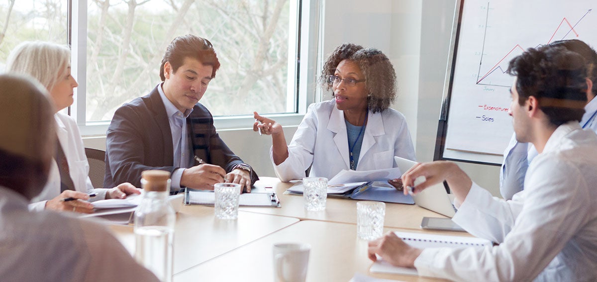 Group of medical practitioners having a serious discussion at a conference table.