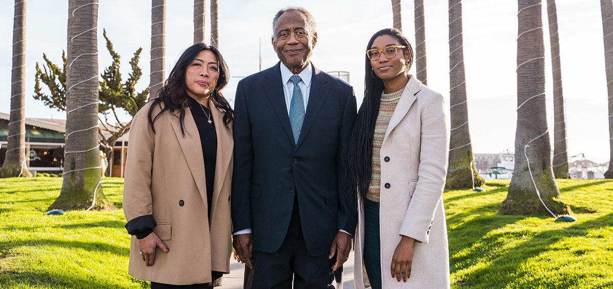 Rowena Robles, Coyness L. Ennix, Jr., and Sequoia Hall standing together at waterfront