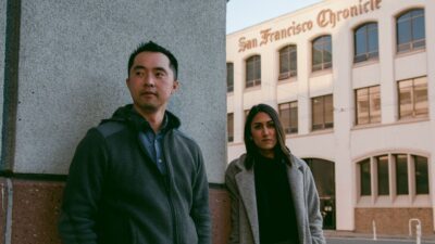 Journalists Trisha Thadani and Stephen Lam stand in front of the San Francisco Chronicle building.