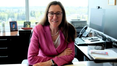 Elizabeth Landsberg sits at desk.
