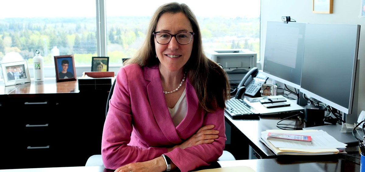 Elizabeth Landsberg sits at desk.