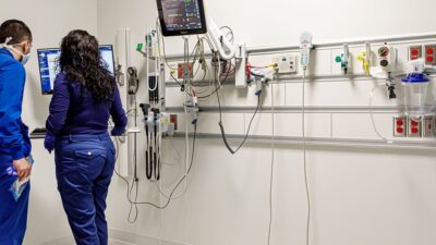 Two medical professionals look at an electronic health record together.