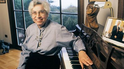 Dr. Joyce Lashof sits at her piano