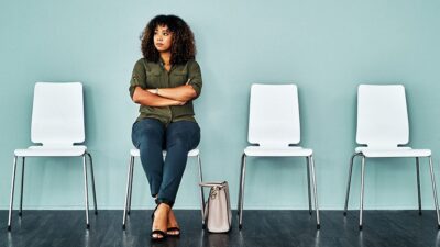 Woman sitting alone, in waiting room.